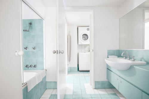 ein Badezimmer mit einem Waschbecken, einer Badewanne und einem WC in der Unterkunft BreakFree Diamond Beach in Gold Coast