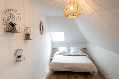 ein kleines Schlafzimmer mit einem Bett im Dachgeschoss in der Unterkunft Le Relais De La Ravine in Vernon