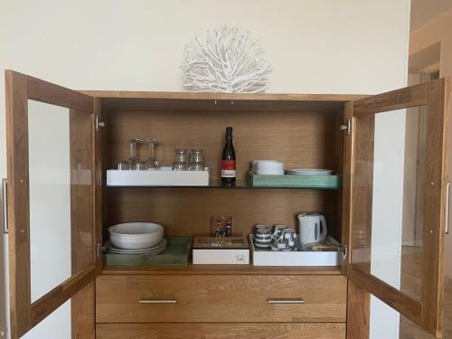 a wooden cabinet with dishes and a bottle of wine at Affittacamere San Giorgio in Manarola