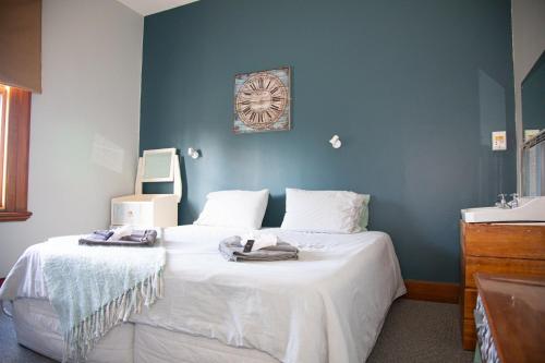 a bedroom with a large white bed with a sink at The Brown Pub in Methven