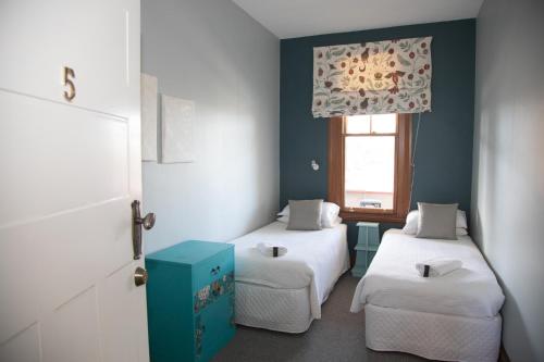 a small room with two beds and a window at The Brown Pub in Methven