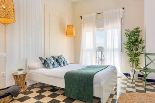 1 dormitorio con cama y ventana en HSH Suites Campana, en Sevilla