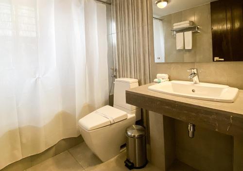 a bathroom with a toilet and a sink at Jatra Flagship Dhaka Lake View in Dhaka
