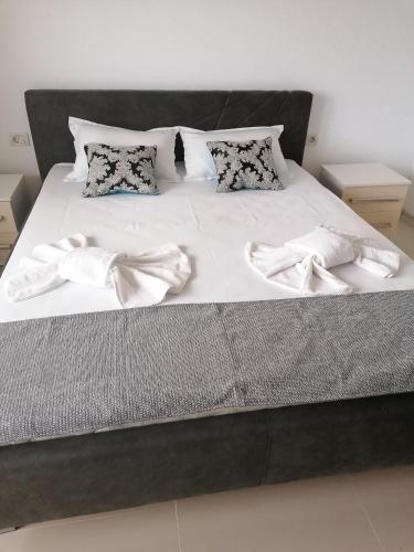 a large bed with white sheets and pillows on it at Azamara in Costinesti