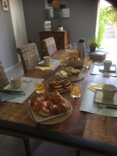 una mesa con pan y otros alimentos. en Chambre les Hortensias, en Challans