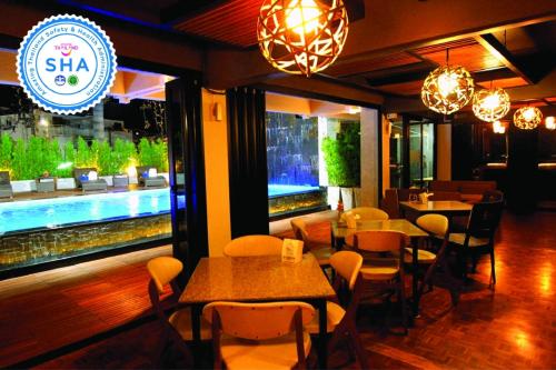 a restaurant with tables and chairs and a pool at Hotel M Chiang Mai in Chiang Mai