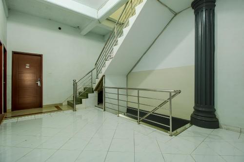 a hallway with stairs and a door and a pole at My Home Aceh in Banda Aceh