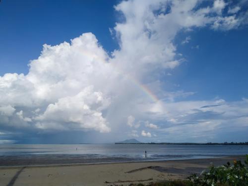 a rainbow in the sky over the beach at Rafflesia Resort in Lundu