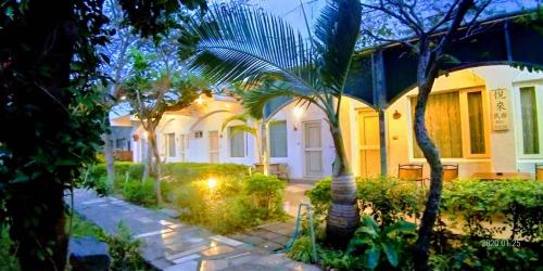 a house with palm trees in front of it at 悦來民宿 台東縣民宿334號 in Taiping