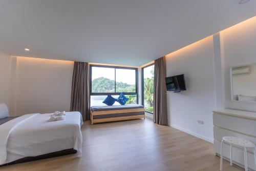 a hotel room with a bed and a window at Bamboo Garden House in Laem Sing