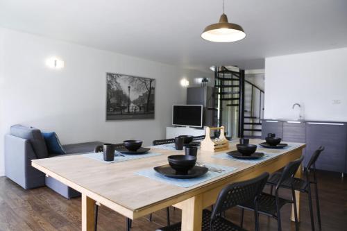 a living room with a wooden table with black bowls on it at Bamboo Garden House in Laem Sing