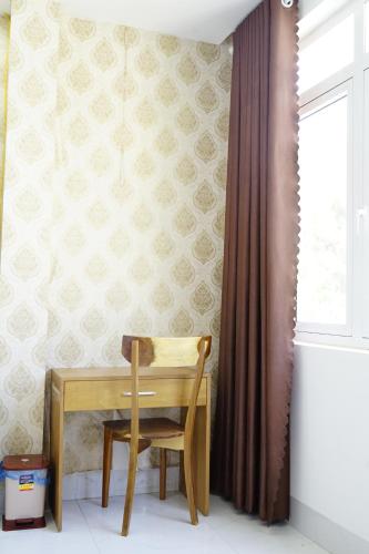 a wooden table and chair in a room with a window at HongKong1 Hotel Quy Nhon in Quy Nhon