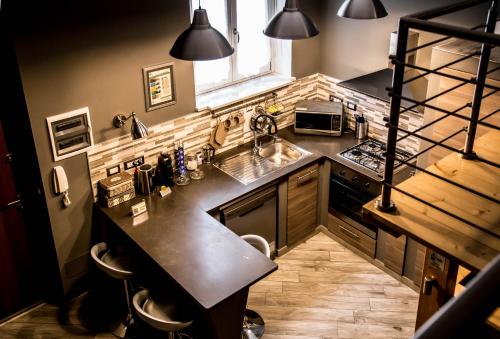 a large kitchen with a sink and a stove at "Here" Mini loft Alghero in Alghero