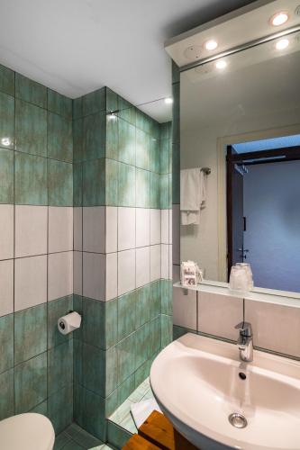 a bathroom with a sink and a toilet and a mirror at Le Preconil in Sainte-Maxime