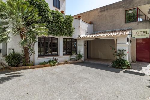 a house with a palm tree and a garage at Le Preconil in Sainte-Maxime