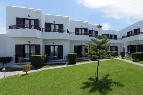 a large white building with a green yard at Geraniotis Hotel and Resort in Plataniás