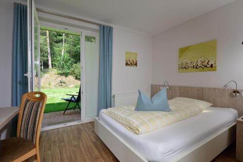 a bedroom with a bed and a large window at Hotel Land-gut-Hotel Wahlde in Grapperhausen