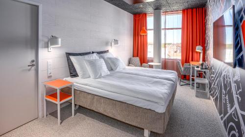 a bedroom with a large bed and a table at Original Sokos Hotel Kupittaa in Turku