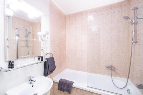 a bathroom with a tub and a sink and a shower at Forums Boutique Hotel in Rīga