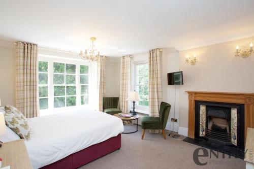 a bedroom with a bed and a fireplace at Woodlands Lodge Hotel in Bartley