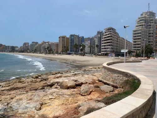a beach with buildings and the ocean and a sidewalk at Service Apart Lazaro- Apartamentos Aguamarina 14 in Calpe