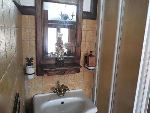 ein Bad mit einem Waschbecken, einem Spiegel und einem Fenster in der Unterkunft La Casina de Abo in El Manto