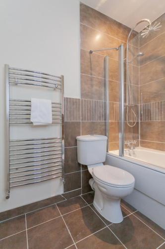 a bathroom with a toilet and a shower and a tub at Escape Ordinary at Castle Hume in Enniskillen
