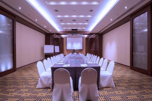 a conference room with a long table and white chairs at Copthorne King's Hotel Singapore in Singapore