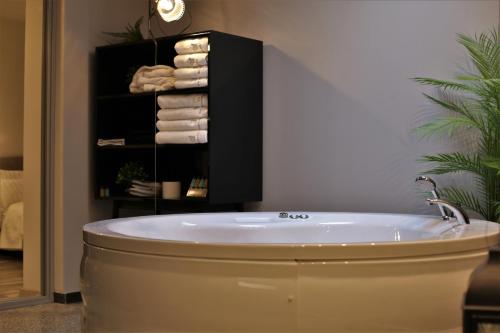 a bath tub in a bathroom with a towel rack at Rooster Suites in Athens