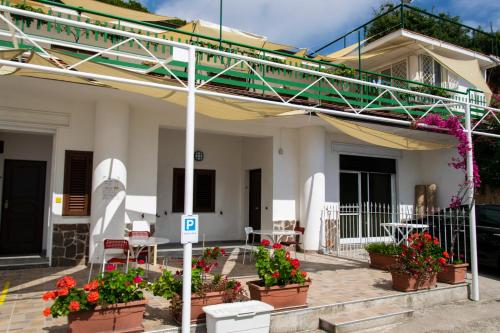 a house with a balcony with flowers in pots at La Meriggia B&B in Pisciotta