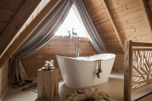 a bathroom with a tub and a window at Villa Hello Tatry in Zakopane