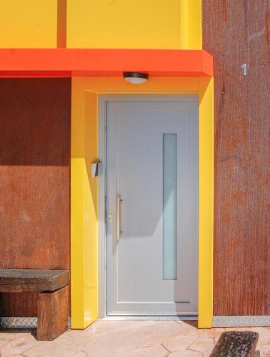 a door in a colorful building with a red and yellow wall at CELTAINER in Maceda