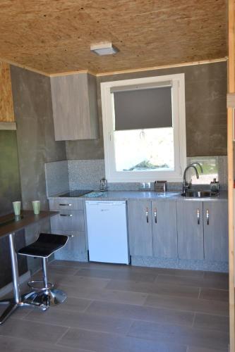 a large kitchen with a sink and a window at CELTAINER in Maceda