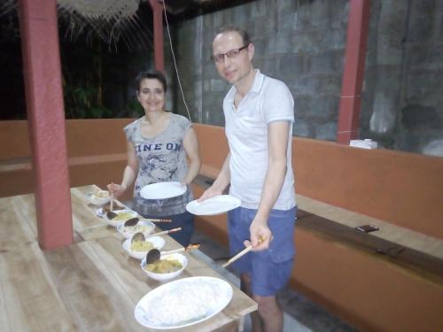a man and woman standing next to a table with food at River Nature Park in Polonnaruwa