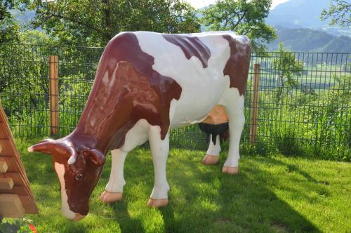 a statue of a cow standing in the grass at Ferienhof Berger in Rossleithen