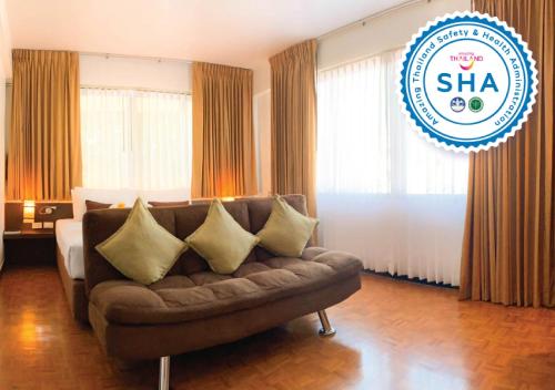 a living room with a couch and a bed at Hotel M Chiang Mai in Chiang Mai