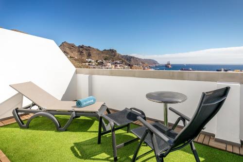 een patio met een tafel en stoelen op een dak bij Occidental Santa Cruz Contemporáneo in Santa Cruz de Tenerife