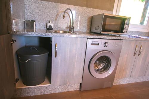 a kitchen with a washing machine and a microwave at CELTAINER in Maceda