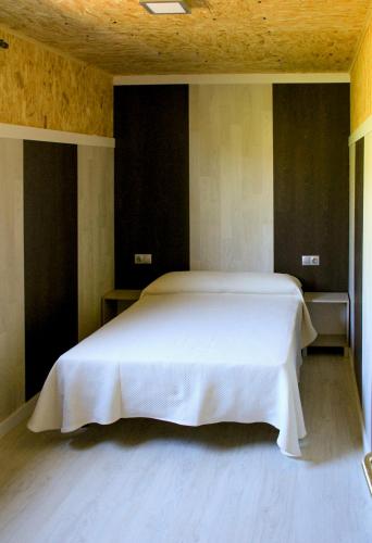 a bedroom with a large white bed in a room at CELTAINER in Maceda