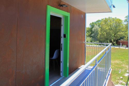 a building with a green door on a balcony at CELTAINER in Maceda