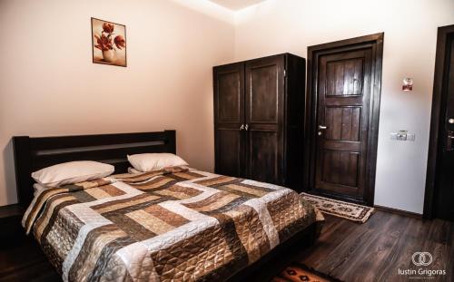 a bedroom with a bed and a wooden floor at Coliba Drumetului in Vatra Dornei