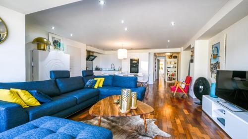 Una sala de estar con un sofá azul y una mesa. en appartement vue mer, en Cannes