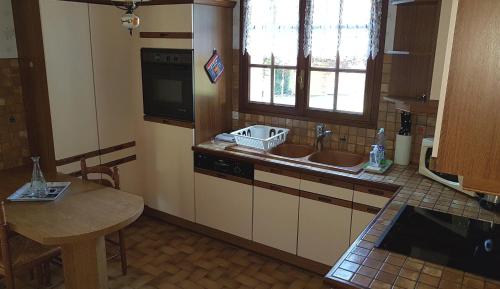 a kitchen with a sink and a counter with a table at La Quietude in Amboise