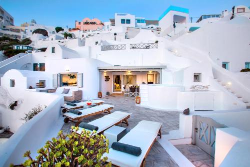 a view of a white house with tables and chairs at 180° Caldera by Stylish Stays in Firostefani