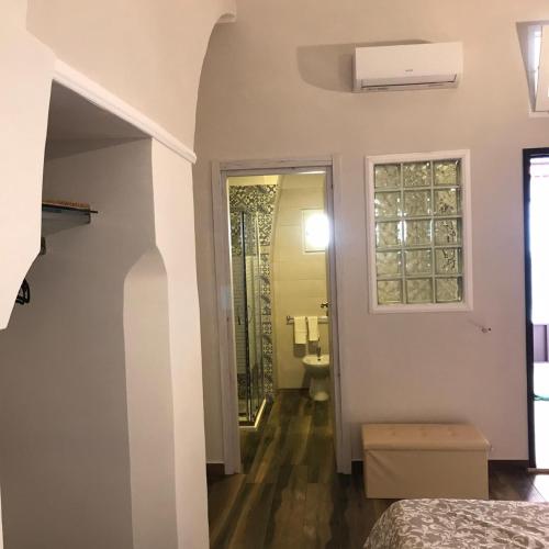a bedroom with a bathroom with a sink and a window at Exclusive Rooms in Trinitapoli