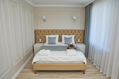 a bedroom with a large bed with towels on it at Rakhat Hotel in Uralsk
