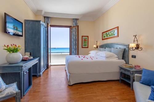 a bedroom with a bed and a view of the ocean at Mira Spiaggia in San Vito lo Capo