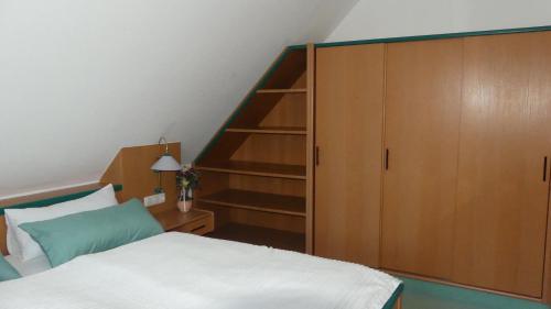 バート・ヴェーリスホーフェンにあるFerienwohnung Mittlのベッドルーム1室(ベッド1台付)、木製キャビネットが備わります。