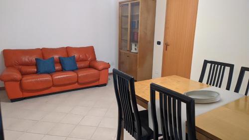 a living room with an orange couch and a table at TOP Apartment in Catanzaro