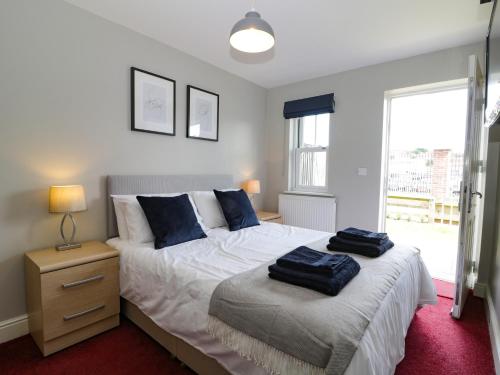 a bedroom with a bed with blue pillows on it at Harbour Walk in Whitby